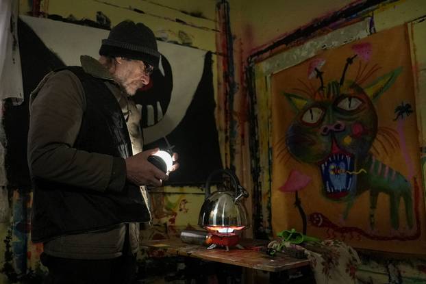 Ukrainian artist works at his studio during a power blackout in Kyiv