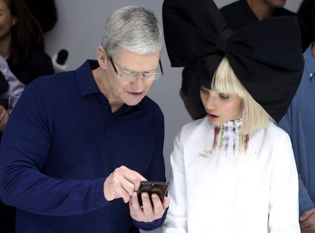 Tim Cook shows Maddie Ziegler an iPhone 7 during an Apple media event in San Francisco