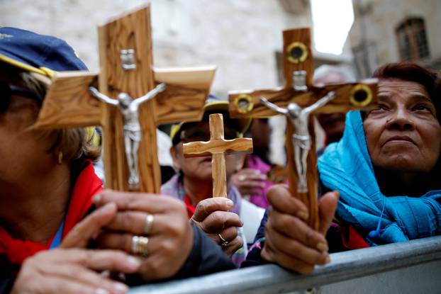 Worshippers hold crucifixes during a Good Friday procession along the Via Dolorosa in Jerusalem