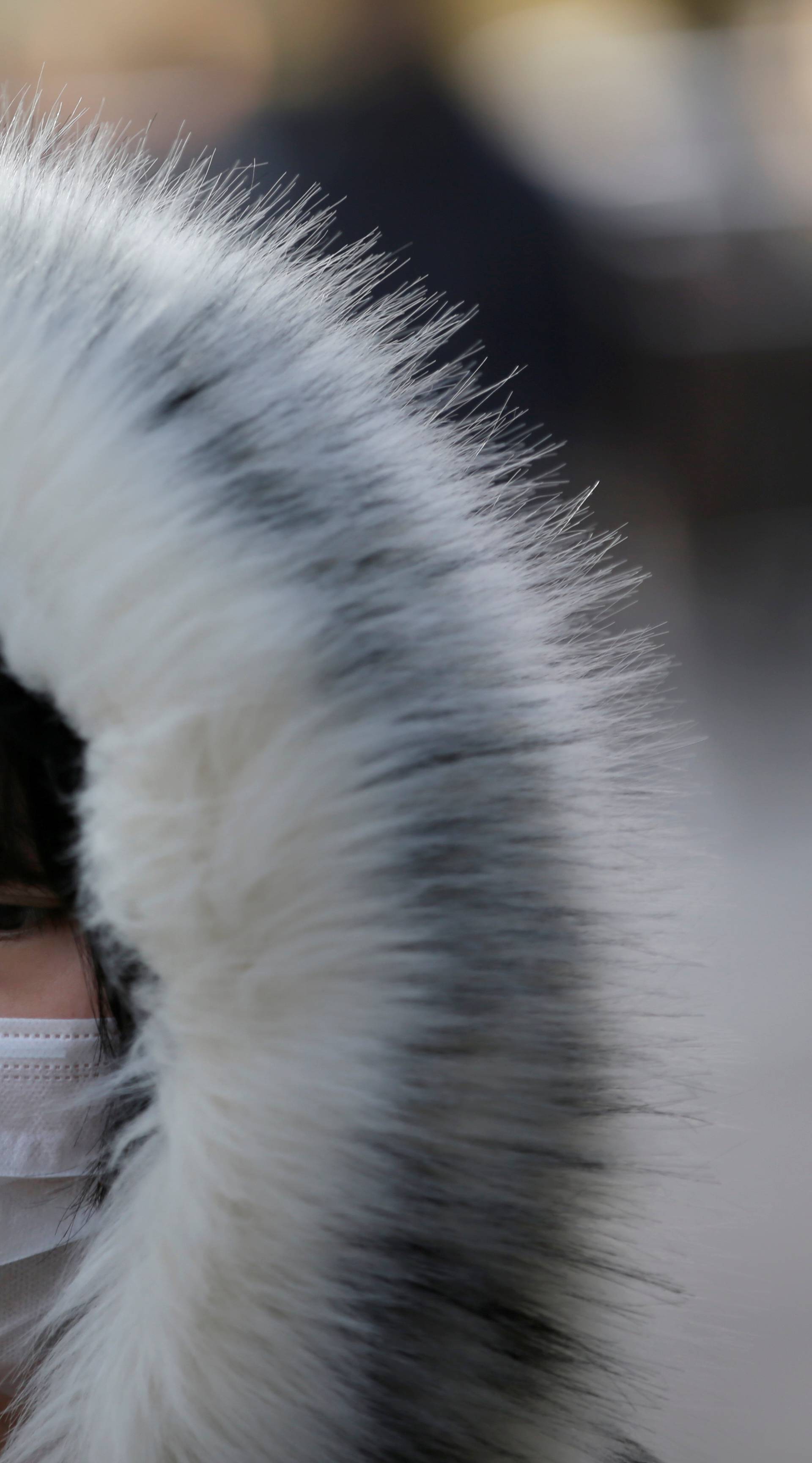 Woman wearing a mask walks along a street in Beijing