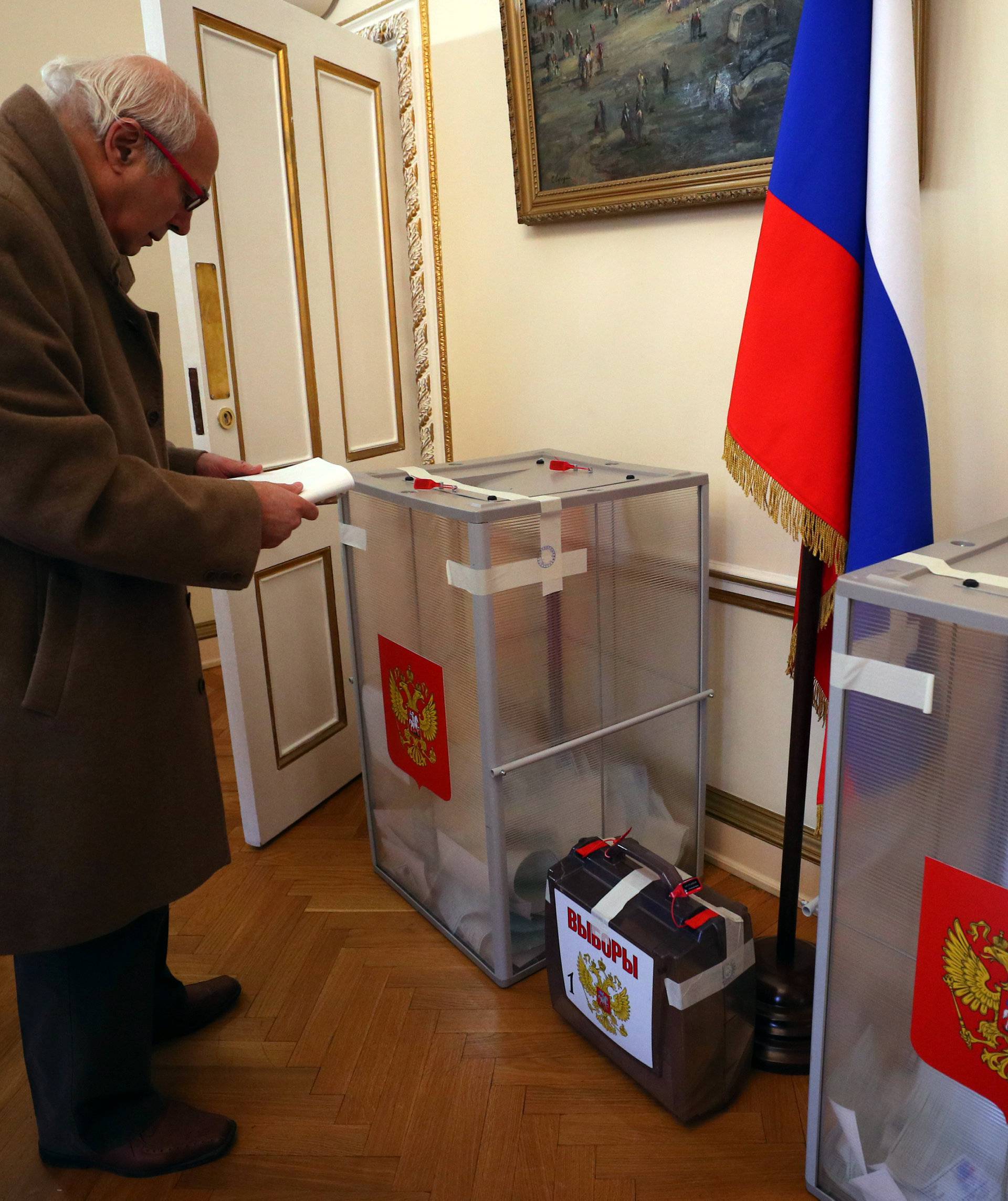 A man approaches a ballot box, during the presidential election, inside the Russian Embassy in London