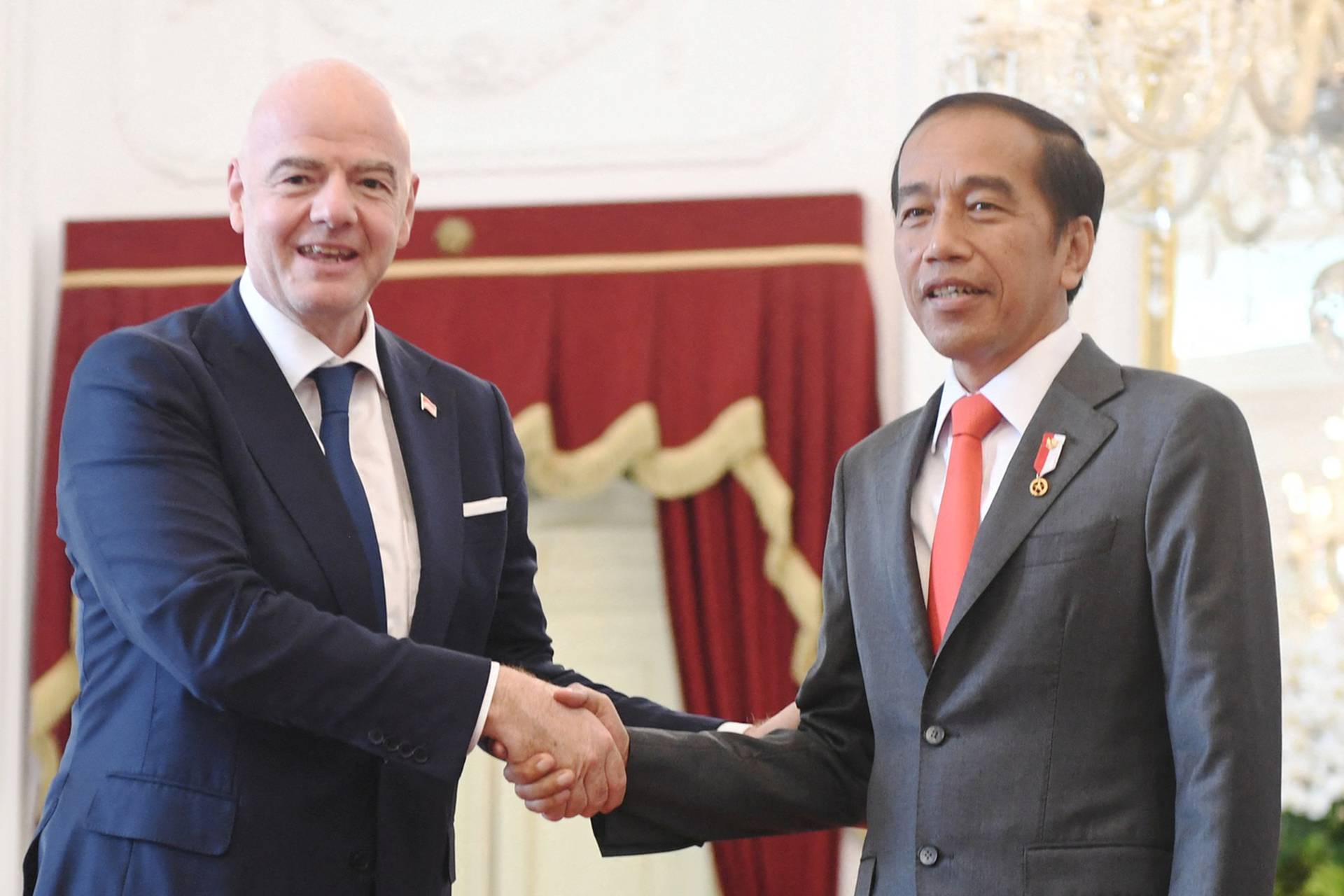 Indonesian President Joko Widodo shakes hands with FIFA’s president Gianni Infantino during their meeting at the Merdeka Palace in Jakarta