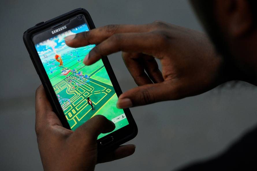A virtual map of Bryant Park is displayed on the screen as a man plays the augmented reality mobile game "Pokemon Go" by Nintendo in New York City
