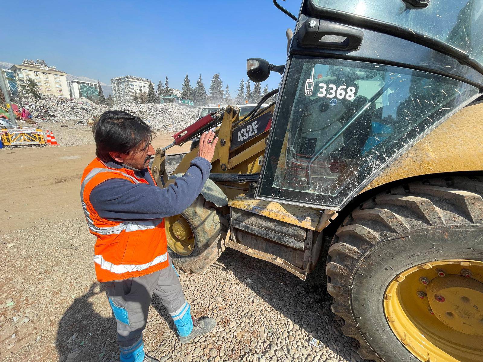 Akin Bozkurt operates a bulldozer at the site of collapsed buildings, taking part in the efforts to find bodies under rubble, in the aftermath of the deadly earthquake, in Kahramanmaras