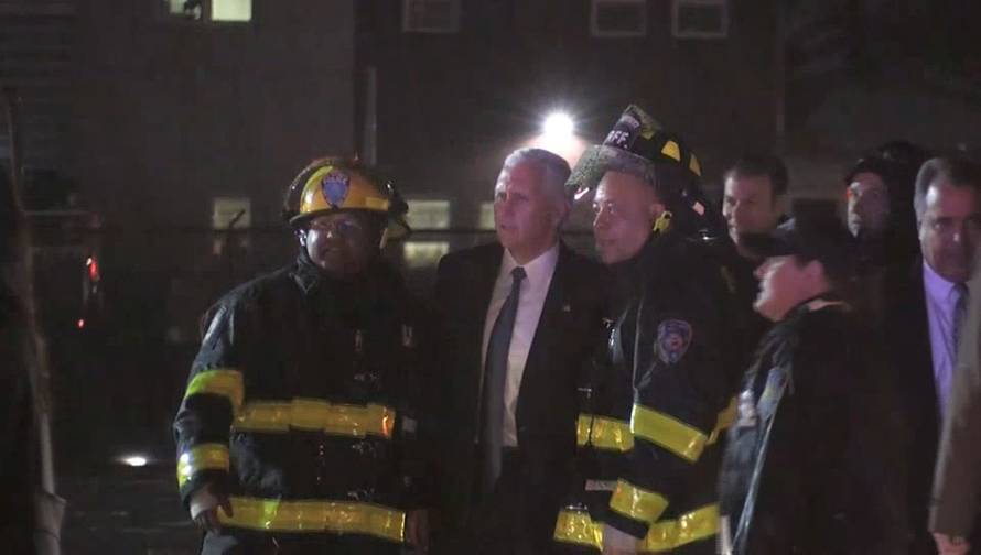 Still image of U.S. Republican vice presidential nominee Pence posing for a photo with firefighters after a plane carrying him skidded off the runway after landing in the rain at New York City's LaGuardia Airport
