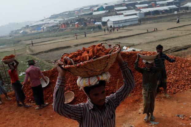 Rohingya refugees carry bricks at Palong Khali camp, near Cox