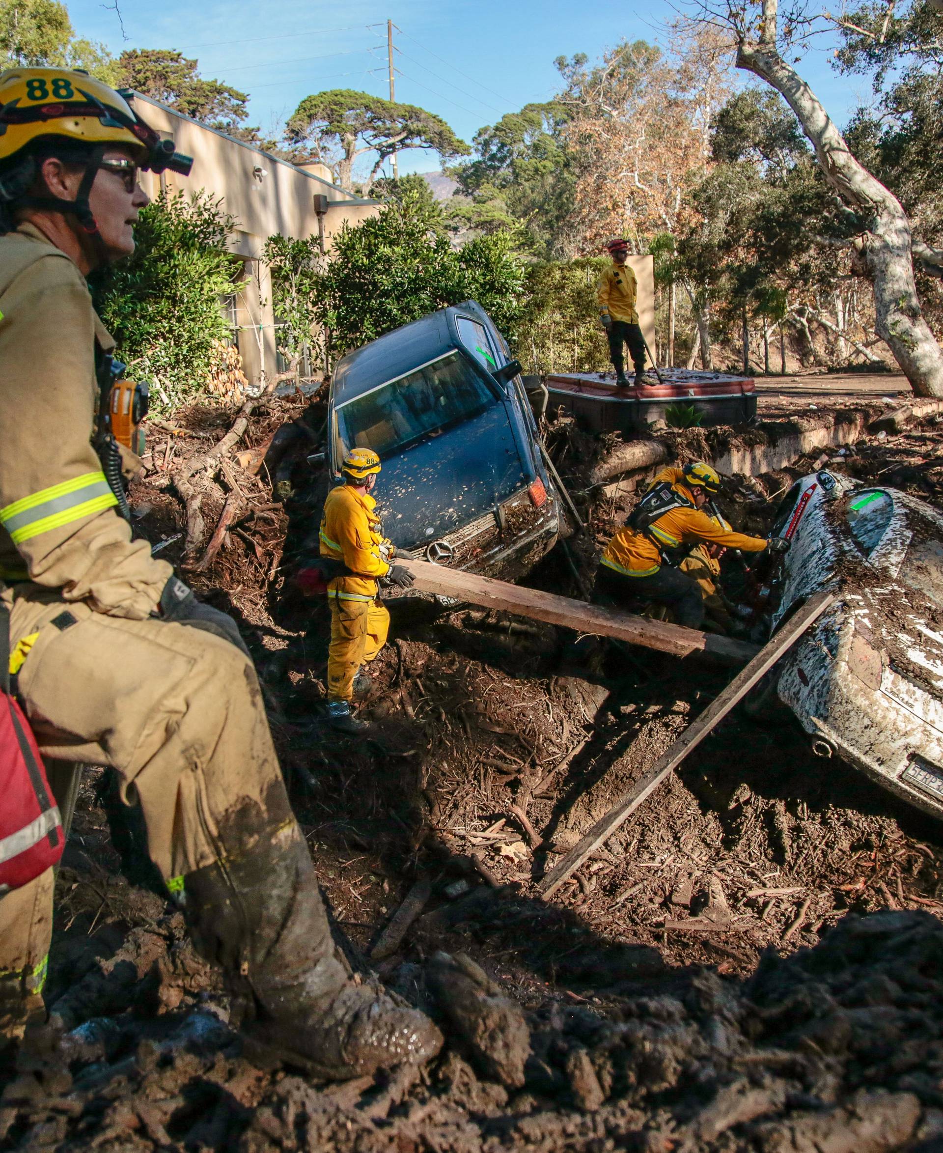 Rescue workers scour through cars after a mudslide in Montecito