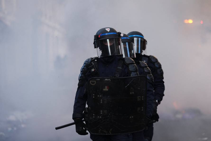 Police officers in riot gear stand guard, the day after a national day of demonstrations against the cost of living and rising fuel prices, in Paris