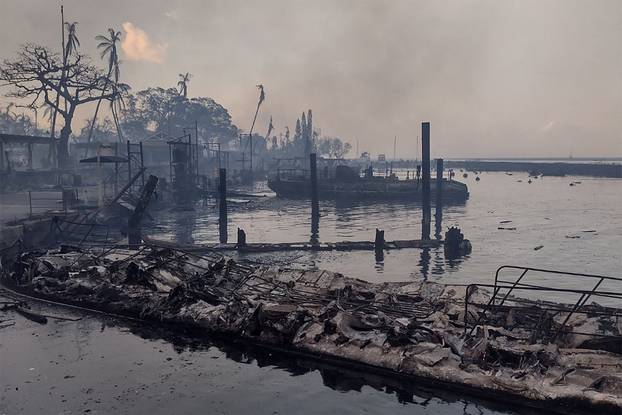 A charred boat lies on the scorched waterfront after a wildfire devastated the Maui city of Lahaina