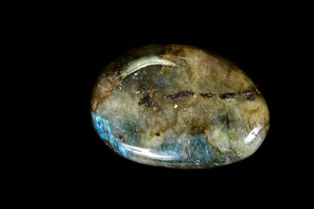 Macro of the stone Labradorite mineral on a black background 
