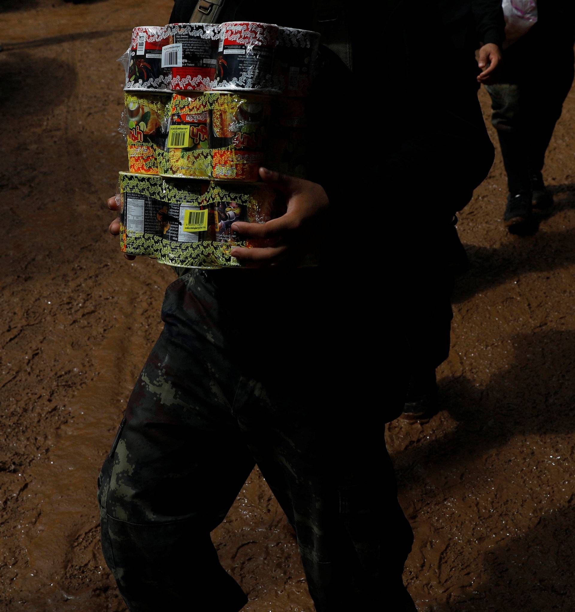 Soldiers carry aid supplies near the Tham Luang cave complex, as members of an under-16 soccer team and their coach have been reported by local media to be found alive, in Chiang Rai