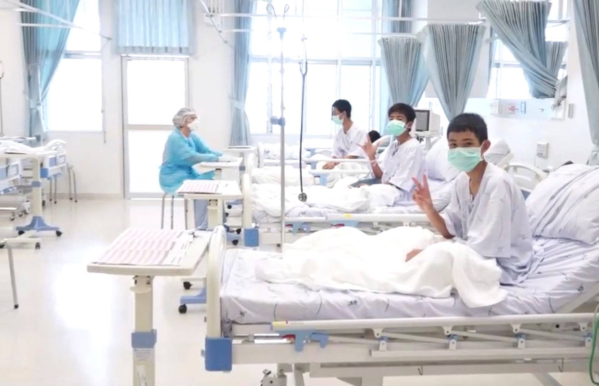 A screen grab shows boys rescued from the Thai cave wearing mask and resting in a hospital in Chiang Rai