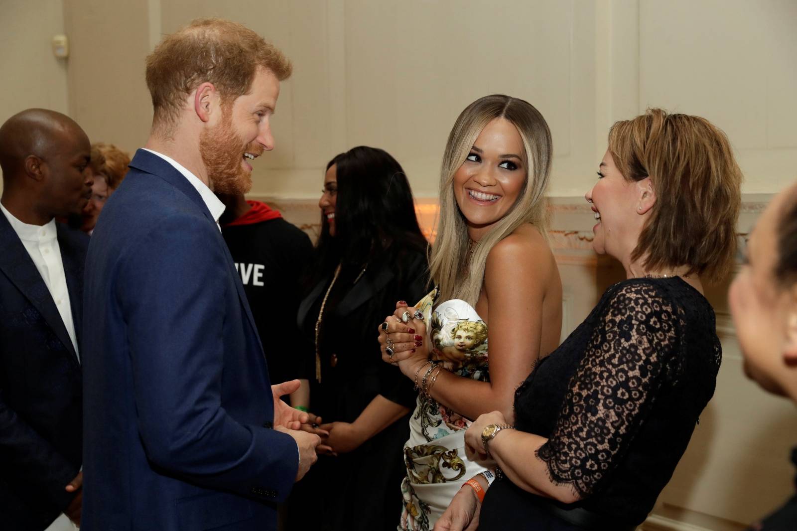 Britain's Prince Harry speaks with singer Rita Ora during a reception before a concert in London