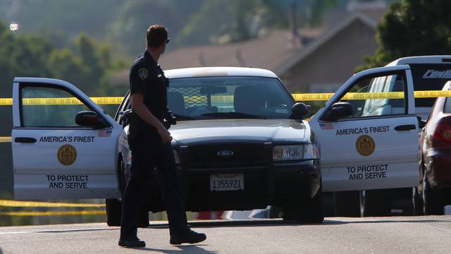 Police block off roads as they protect a crime scene and search for a second suspect after a San Diego police officer was fatally shot and another was wounded late on Thursday, in San Diego