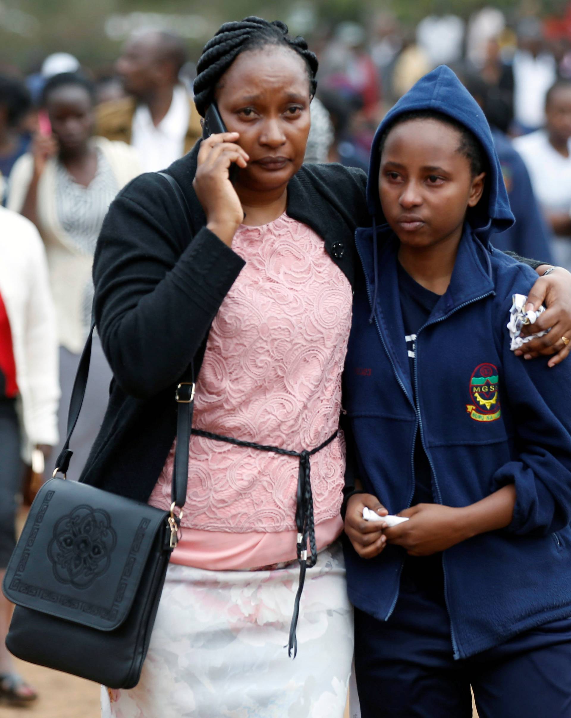 A parent embraces a student following a fire which burnt down one dormitory of Moi Girls school in Nairobi