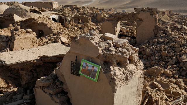 A family picture can be seen on a wall of a damaged house after the recent earthquake in Chahak village