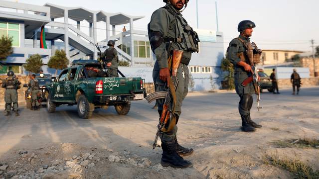 Afghan police officers stand guard at the site of a suicide attack in Kabul, Afghanistan