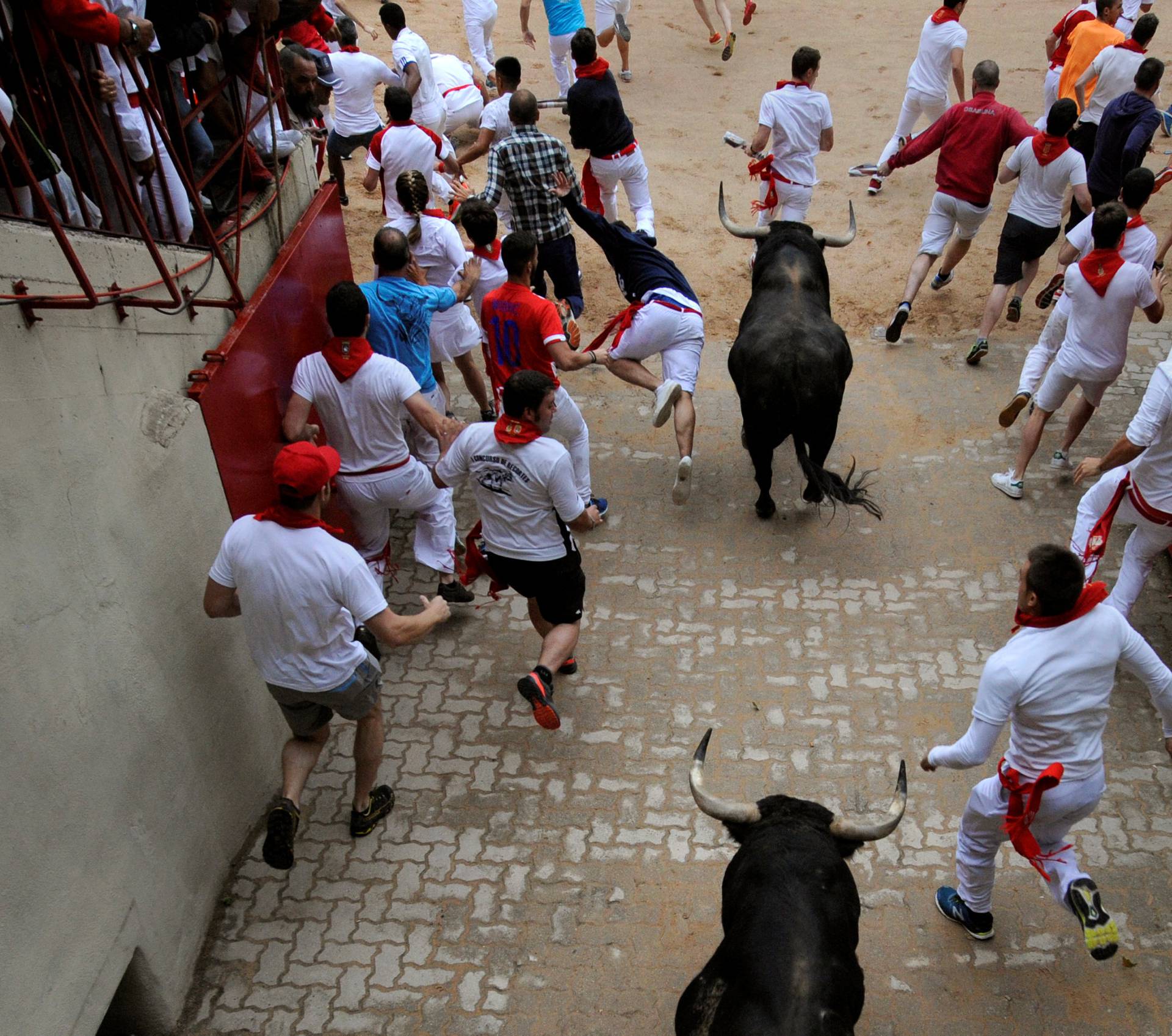 Runners sprint ahead of Fuente Ymbro fighting bulls during the fourth running of the bulls at the San Fermin festival in Pamplona