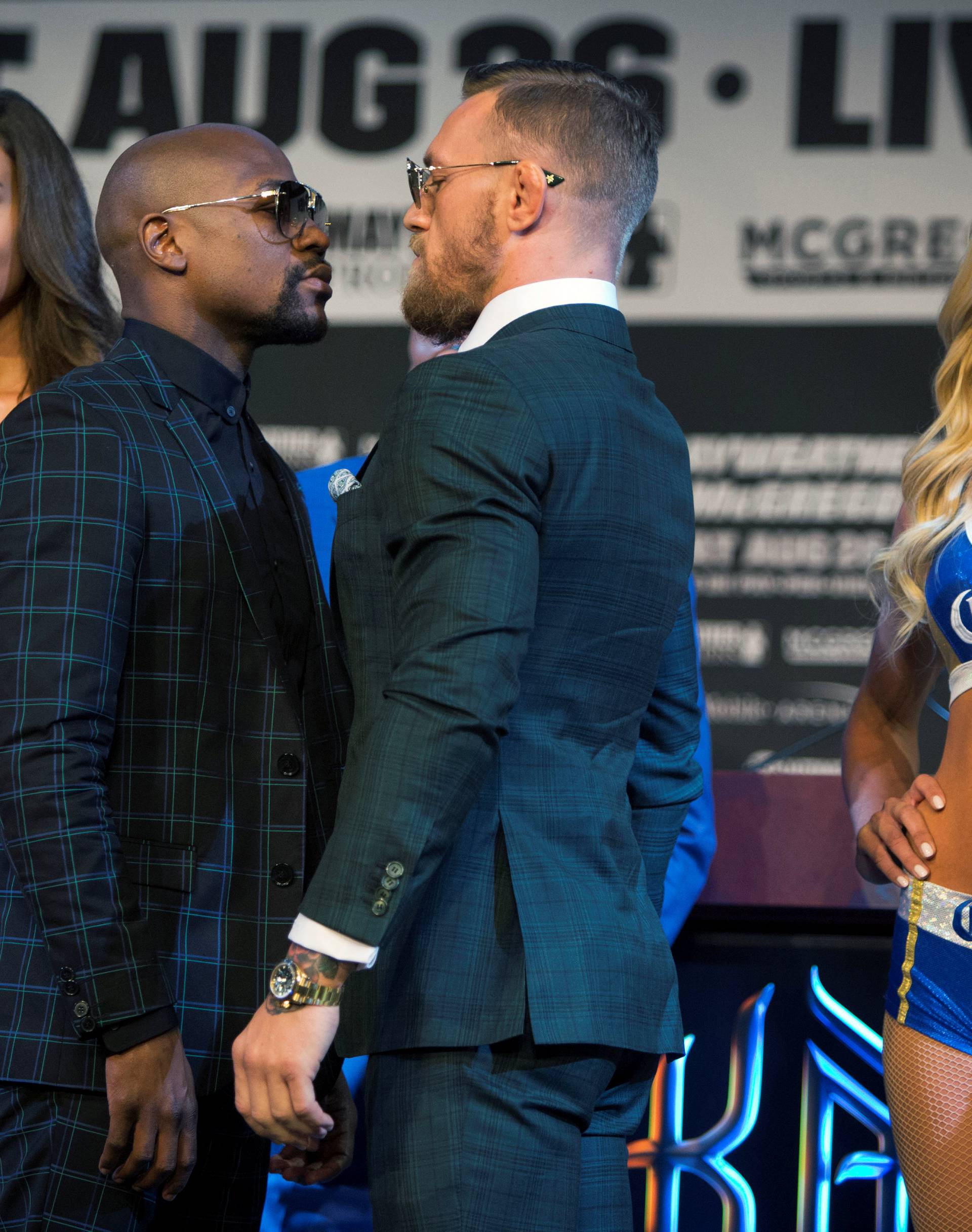 Undefeated boxer Floyd Mayweather Jr. (L) of the U.S. and UFC lightweight champion Conor McGregor of Ireland face off during a news conference in Las Vegas