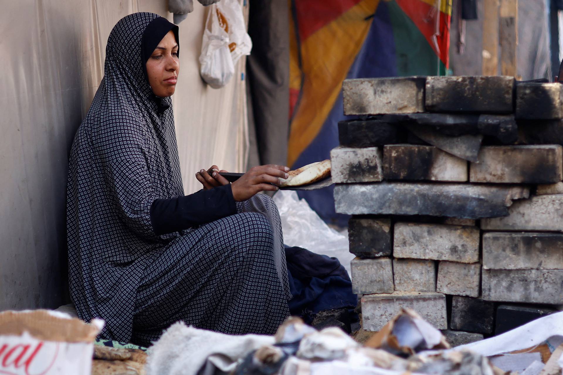 Displaced Palestinians, who fled their houses due to Israeli strikes, shelter at a tent camp in Rafah