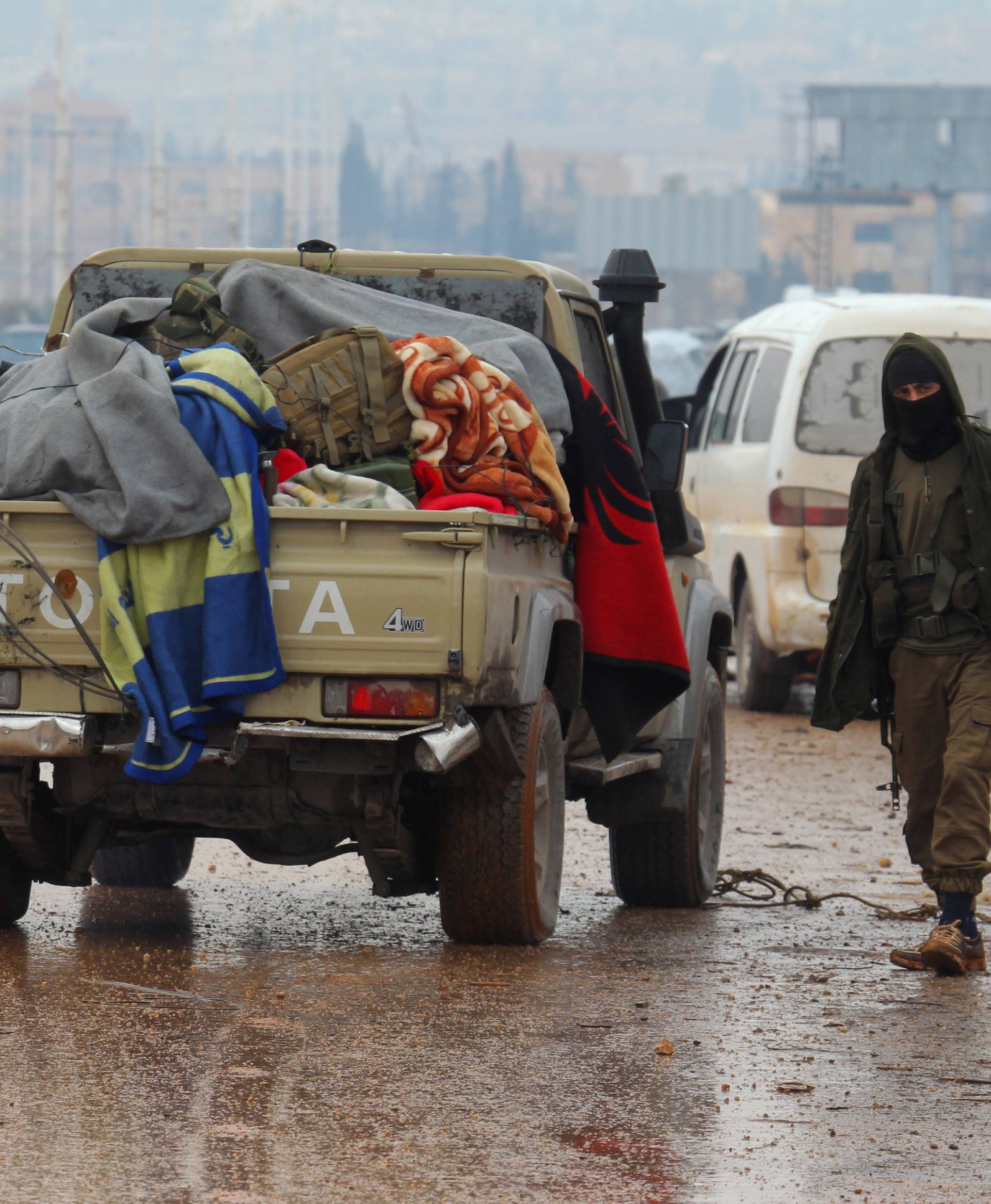 A rebel fighter stands near vehicles at insurgent-held al-Rashideen in the province of Aleppo