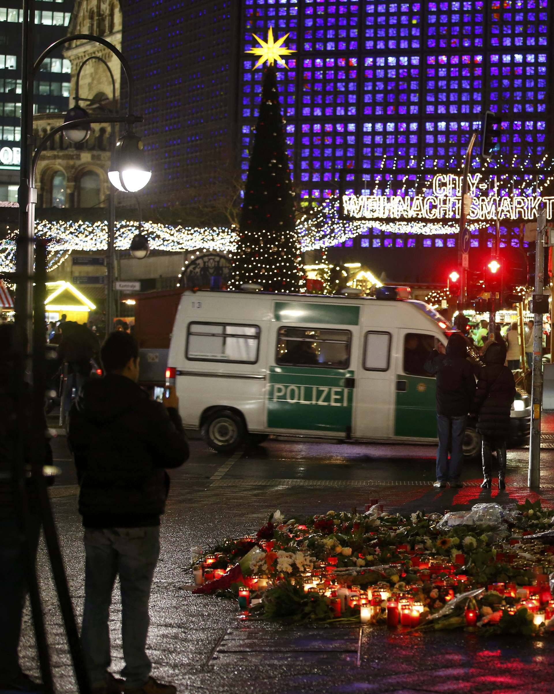 Flowers and candles are placed near the Christmas market at Breitscheid square in Berlin