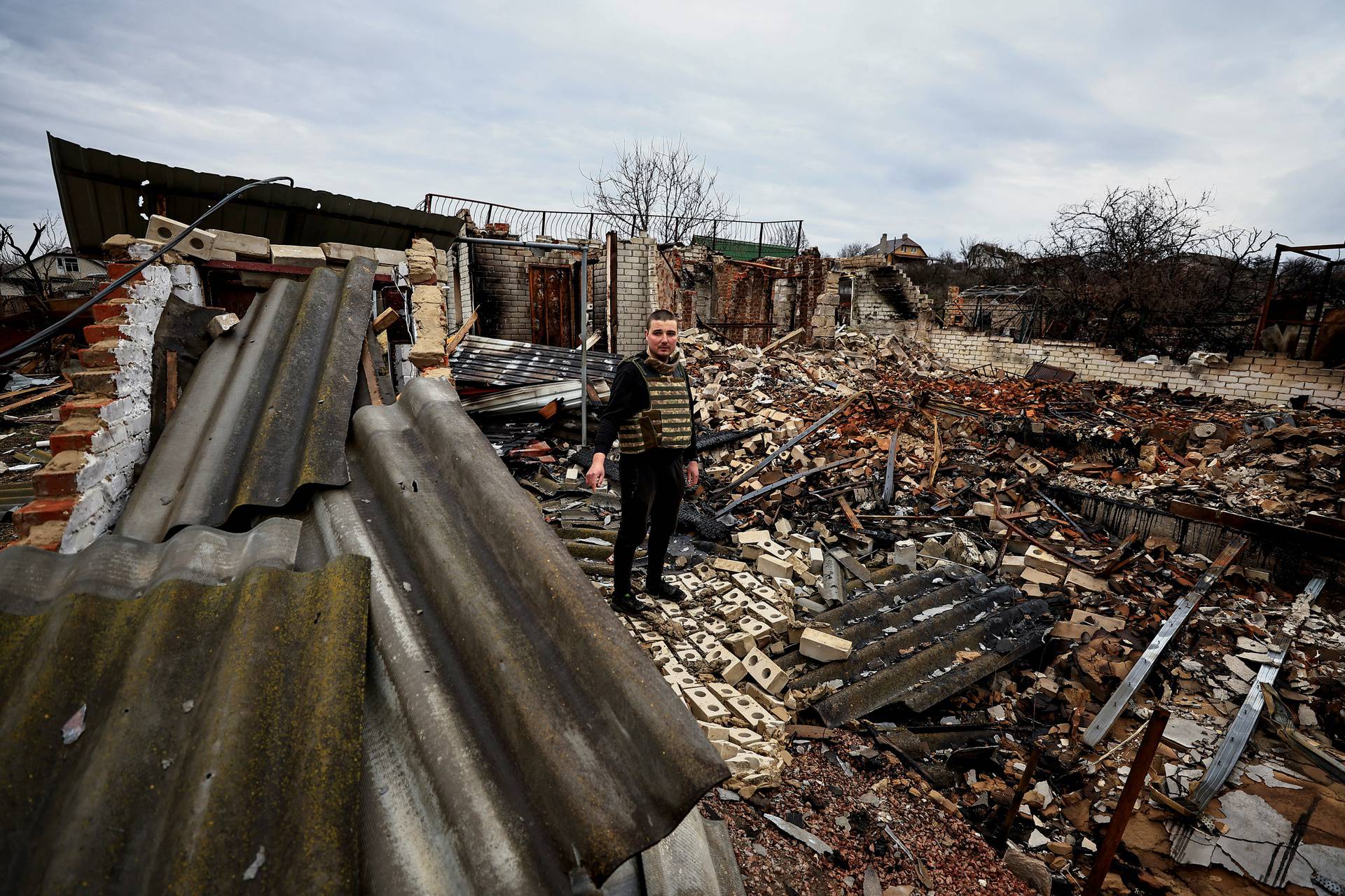 Markov Oleksandr, 32 and a sales man turned into a humanitarian aid volunteer, speaks to journalists as he stands on the rubbles of his parents' house, which was destroyed by shelling amid Russia's Invasion of Ukraine, in Chernihiv