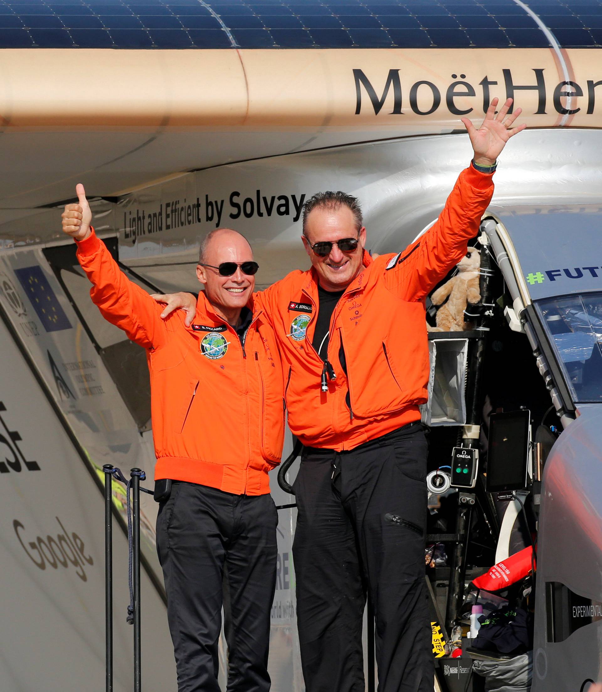 Andre Borschberg, the Swiss pilot of Solar Impulse 2, is greeted by fellow pilot and countryman Bertrand Piccard after landing at Cairo Airport