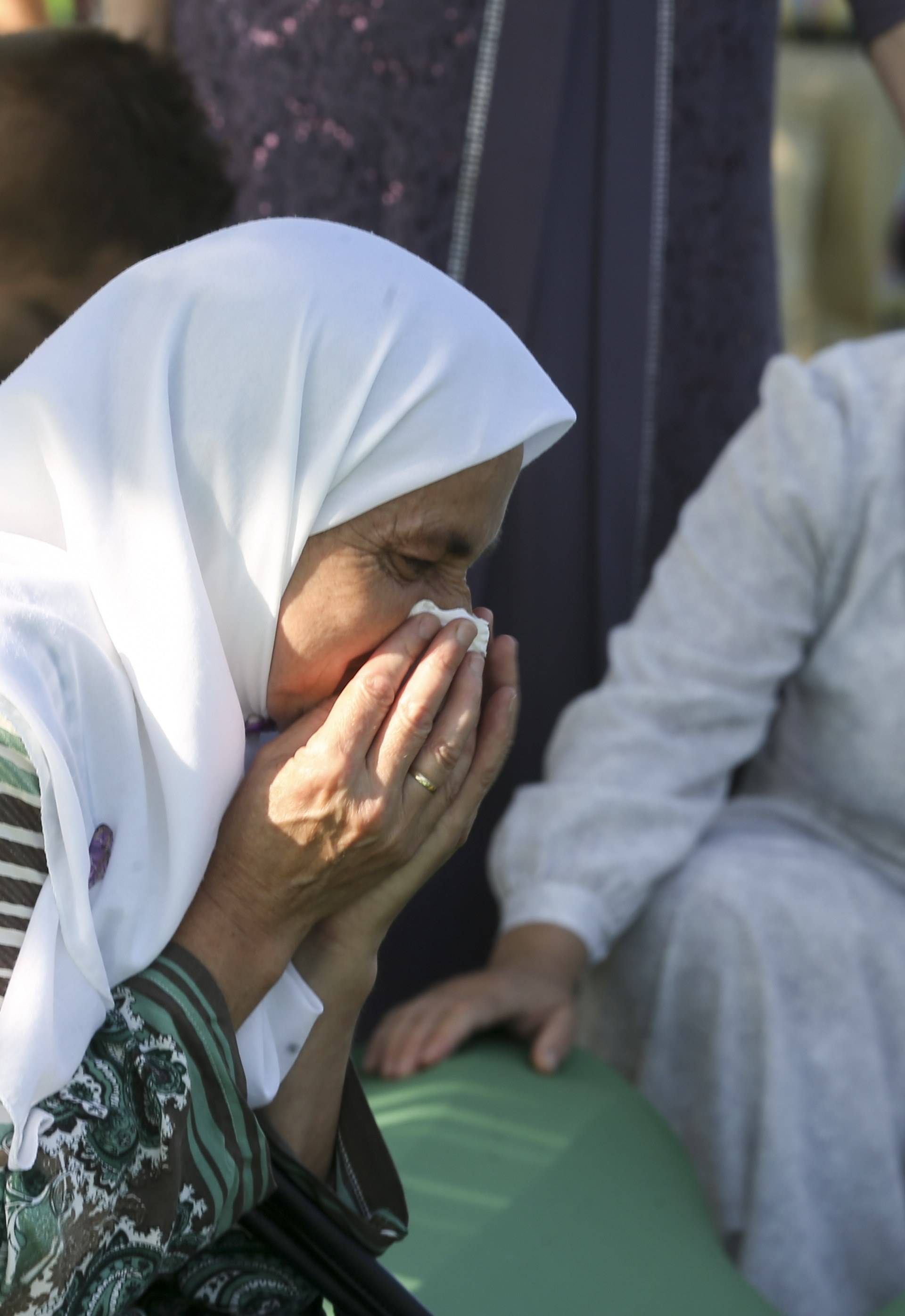 People mourn near coffins of their relatives, who are newly identified victims of the 1995 Srebrenica massacre, which are lined up for a joint burial in Potocari near Srebrenica