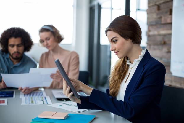 FEMALE BUSINESS EXECUVIVA CONSIT DIGITAL TABLET IN OFFICE