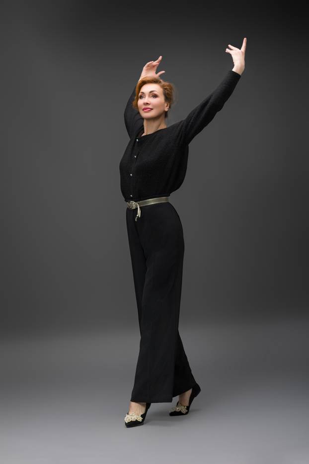 Elegant woman in stylish black outfit posing in studio