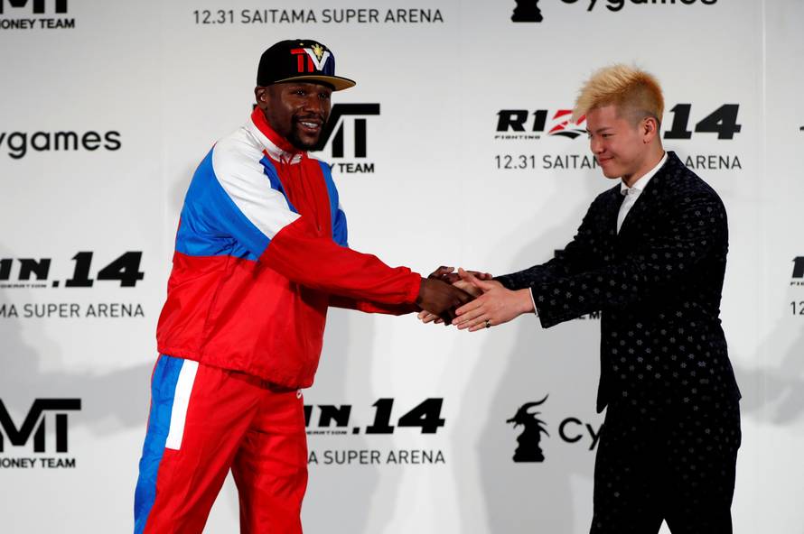 Boxer Floyd Mayweather Jr. of the U.S. shakes hands with his opponent Tenshin Nasukawa during a news conference inn Tokyo