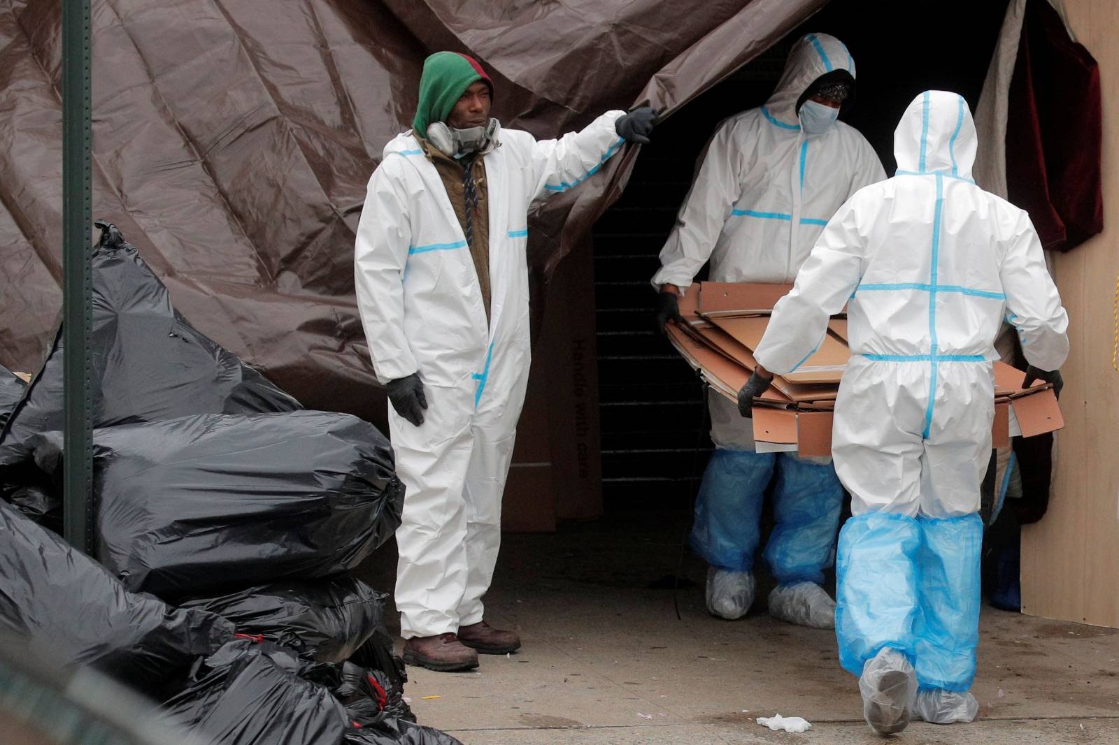 Workers are seen outside the Andrew T. Cleckley Funeral Services funeral home during the outbreak of the coronavirus disease (COVID-19) in Brooklyn, New York