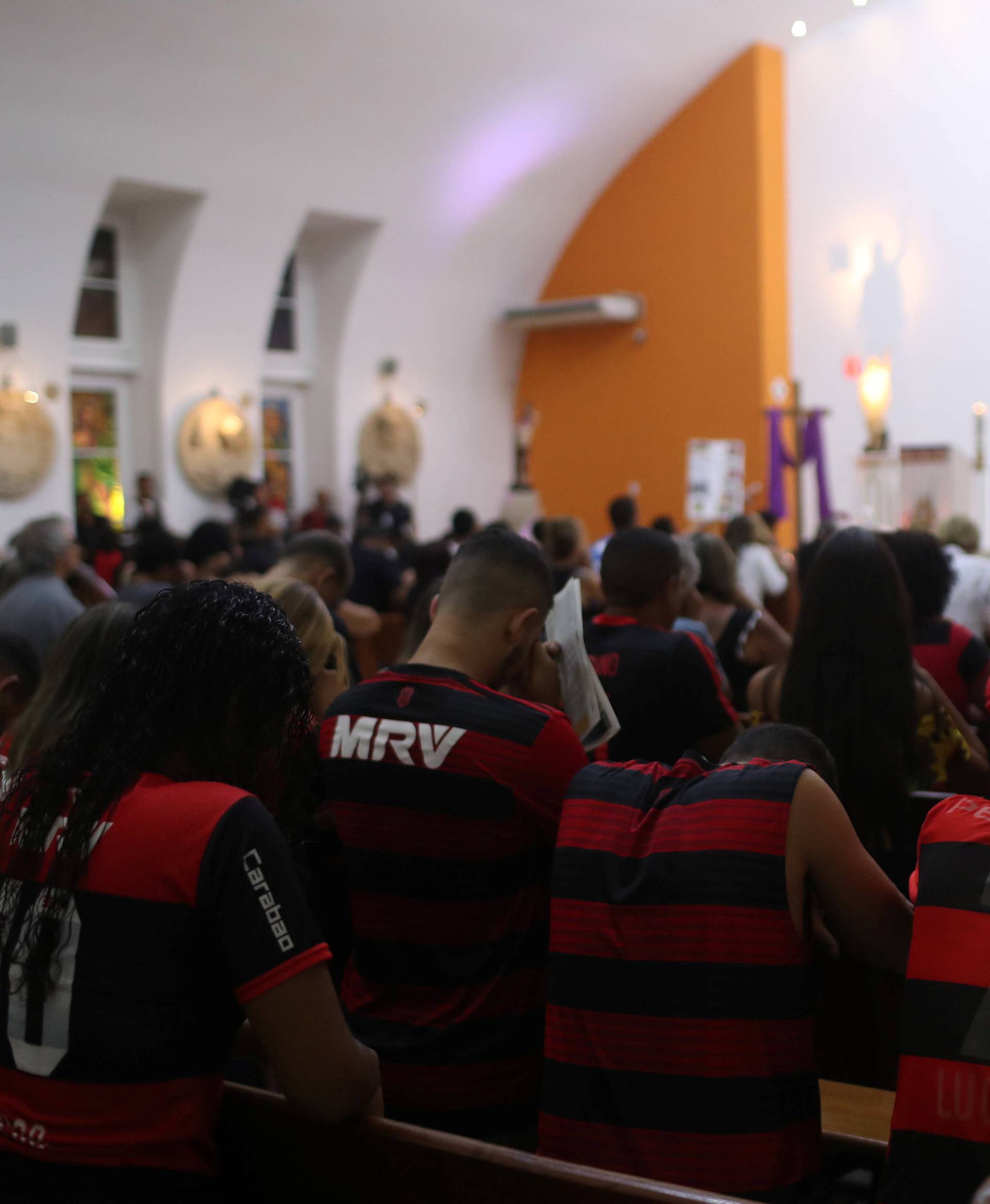 Supporters of Flamengo pray during a mass in memory of the victims of the club's training center deadly fire in Rio de Janeiro