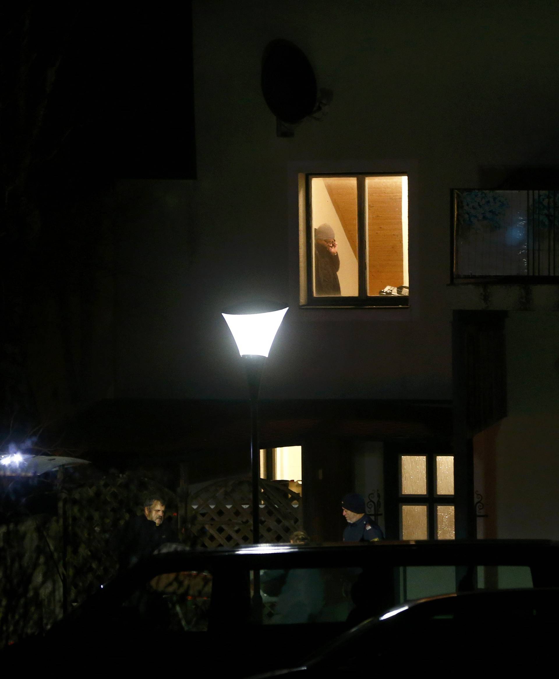 Police are seen in front of a house where six people were found dead in Boeheimkirchen