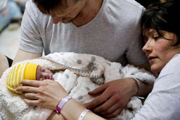 A couple with their newborn baby take shelter in the basement of a perinatal centre as air raid siren sounds are heard amid Russia's invasion of Ukraine, in Kyiv