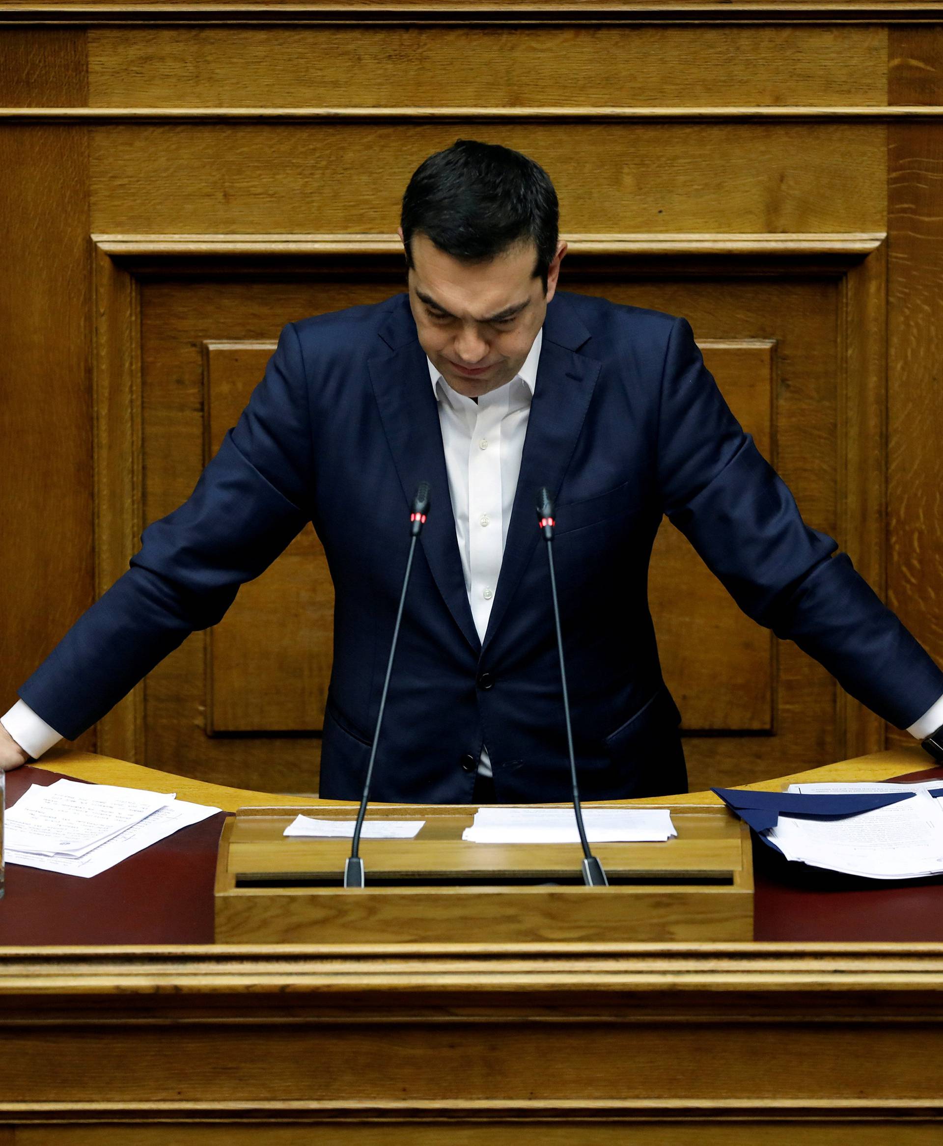 Greek PM Tsipras pauses as he addresses lawmakers during a parliamentary session before a confidence vote in Athens