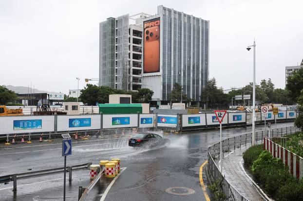 A car passes through a puddle of water after Super Typhoon Ragasa, in Shenzhen