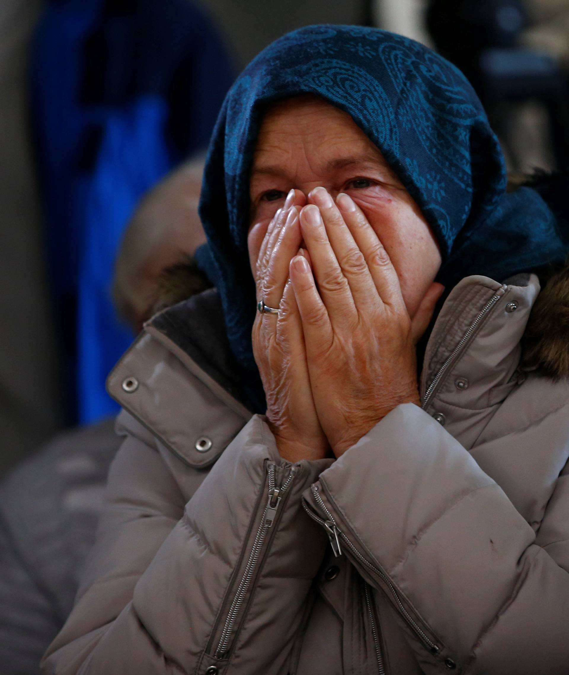 A woman reacts as she watches a television broadcast of the court proceedings of former Bosnian Serb general Ratko Mladic in the Memorial centre Potocari near Srebrenica