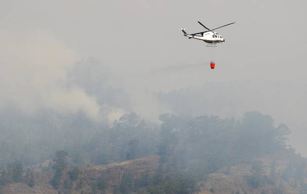A helicopter prepares to discharge water amid the Arico forest fire on the Spanish island of Tenerife