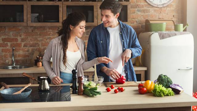Happy,Couple,Cooking,Dinner,Together,In,Their,Loft,Kitchen,At
