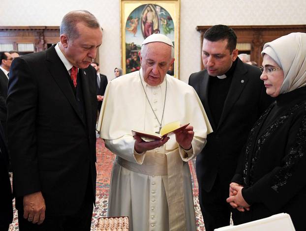 Pope Francis exchanges gift with Turkish President Tayyip Erdogan and his wife Emine during a private audience at the Vatican