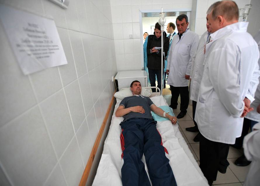Russian President Vladimir Putin meets with victims injured during a fire in a shopping mall, at a hospital in Kemerovo