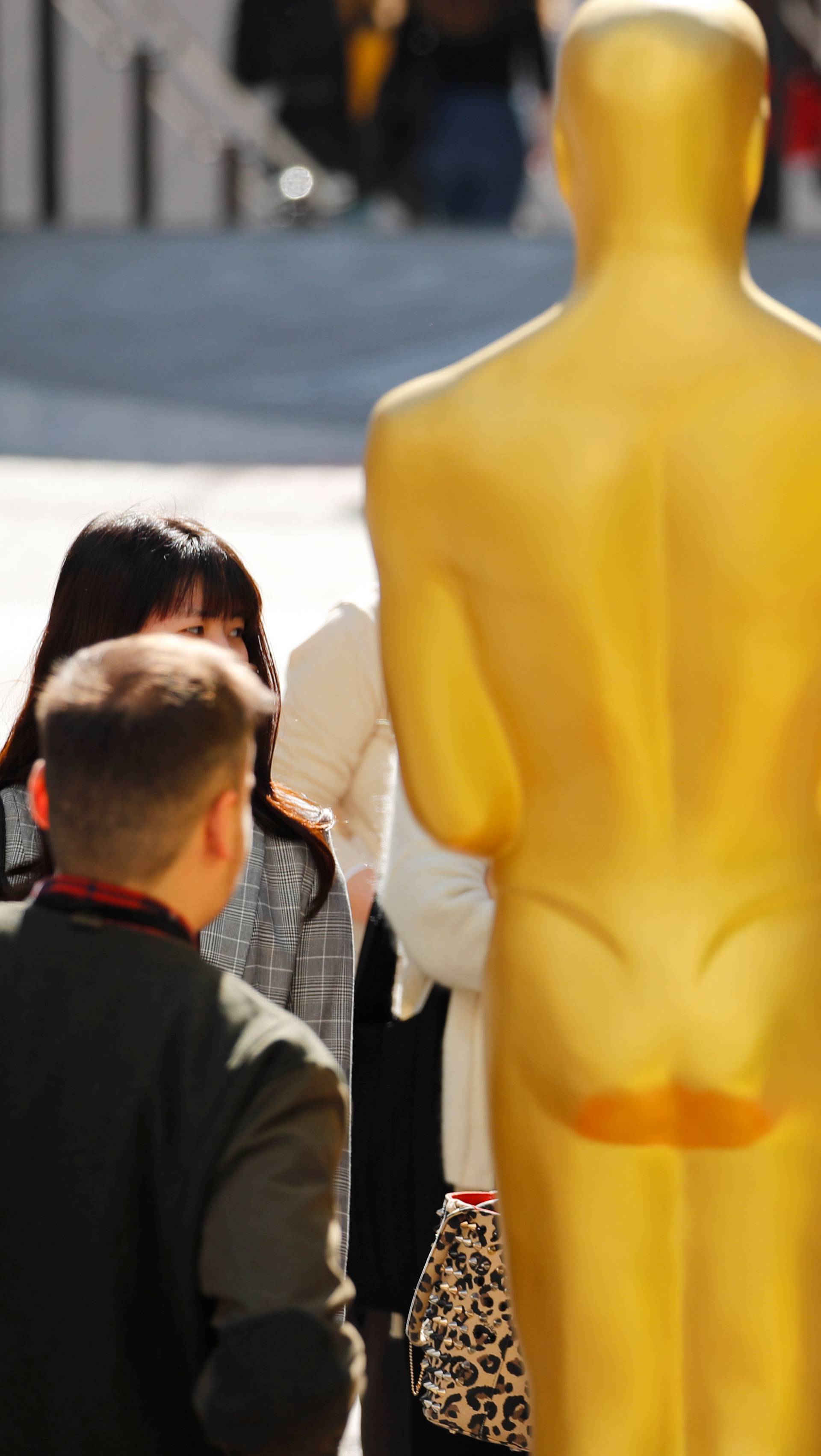 People crowd around an Oscar statue as preparation for the 92nd Academy Awards continues in Los Angeles