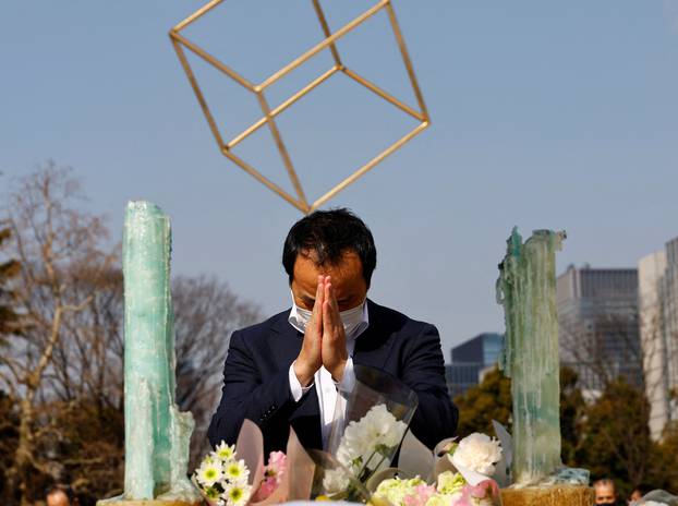 A man wearing a protective mask prays to mourn the victims of the March 11, 2011 earthquake and tsunami, on the 11th anniversary of the events that killed thousands and set off a nuclear crisis, in Tokyo