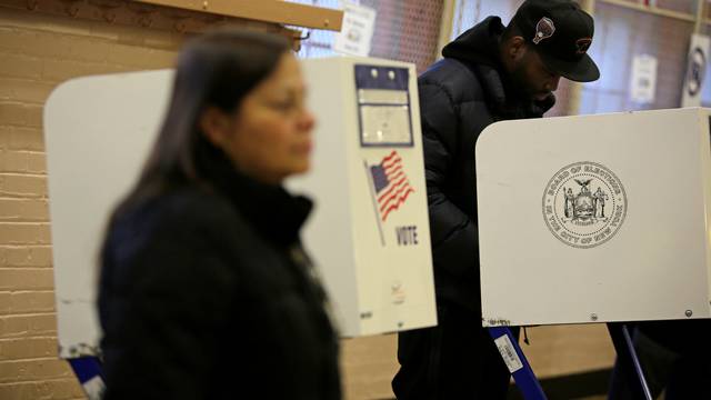 A voter casts his ballot behind a ballot booth during the U.S. presidential election at a polling station in the Bronx Borough of New York
