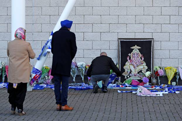 Leicester City football fans pay their respects outside the football stadium, after the helicopter of the club owner Thai businessman Vichai Srivaddhanaprabha crashed when leaving the ground on Saturday evening after the match, in Leicester