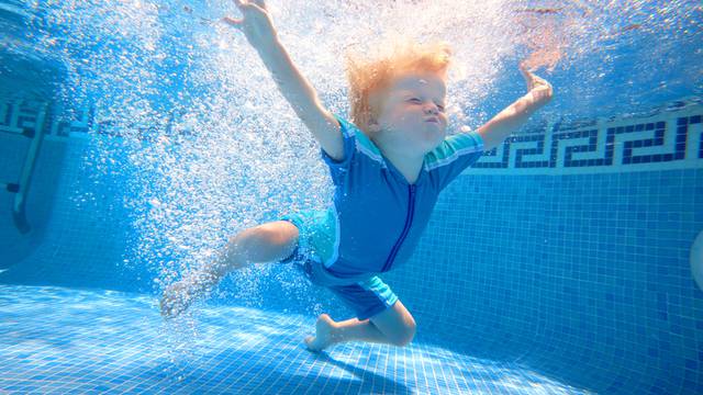 Young boy underwater in swimming pool