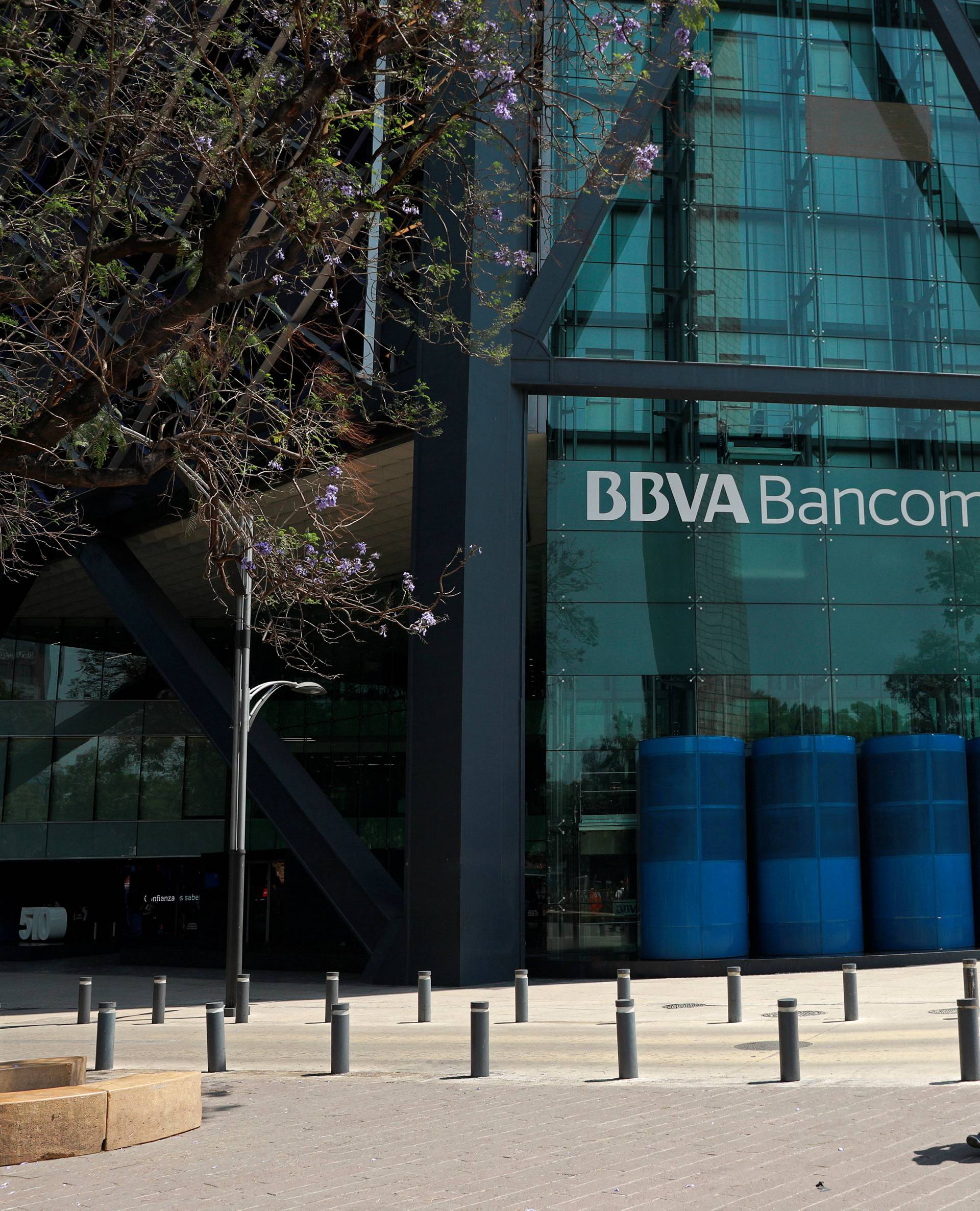 People walk past the BBVA building after its evacuation, in Mexico City