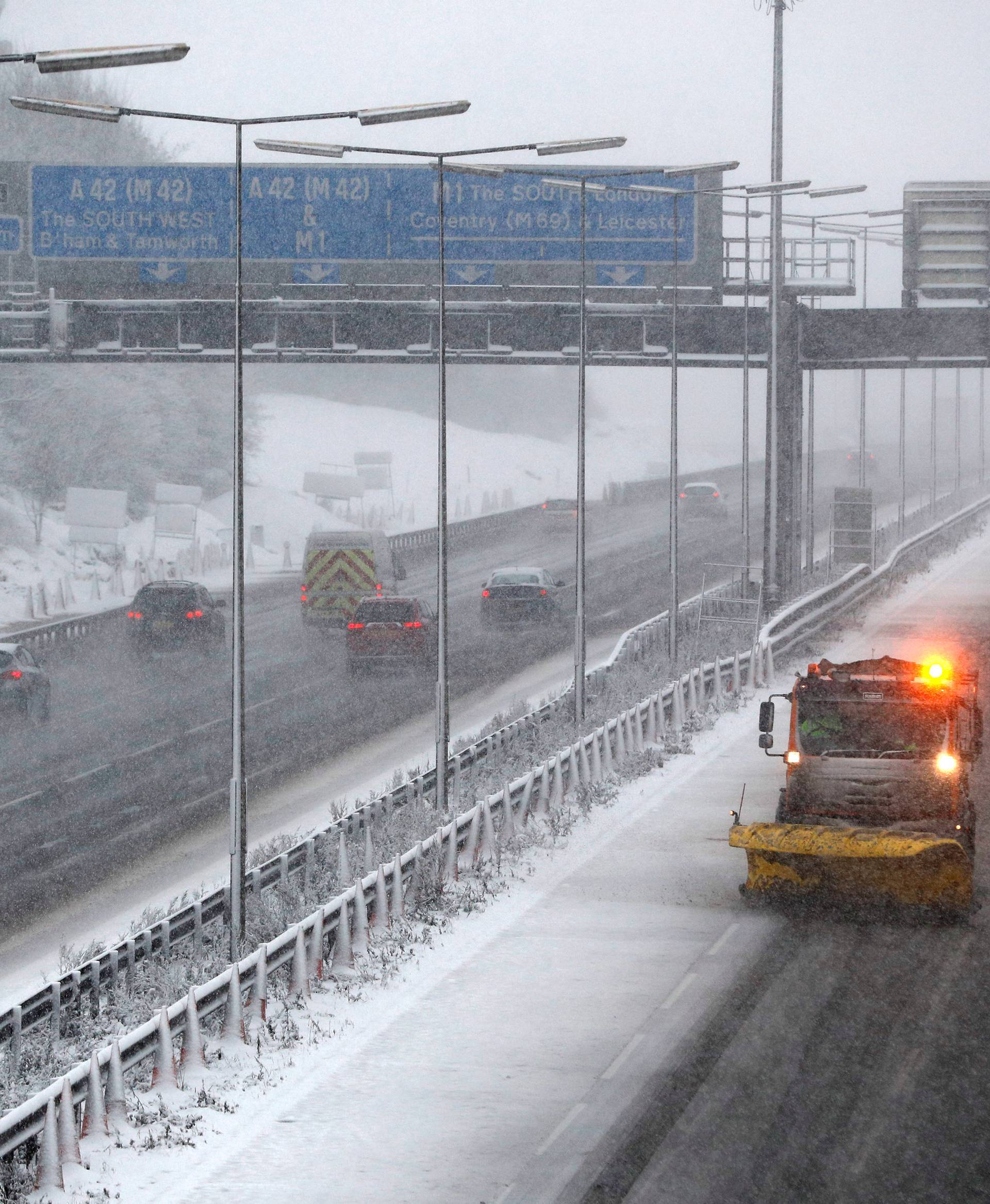 A road gritting vehicle treats the M1 motorway as the snow falls near Kegworth